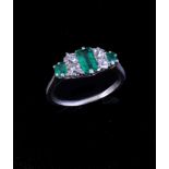 An emerald and diamond ring