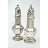 Two similar silver octagonal vase shaped sugar casters