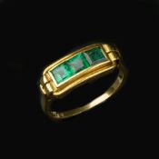 A gold coloured emerald ring