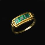 A gold coloured emerald ring