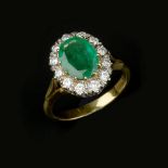 An emerald and diamond cluster ring