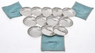 A set of twelve American silver coloured plain round dishes by Tiffany & Co.