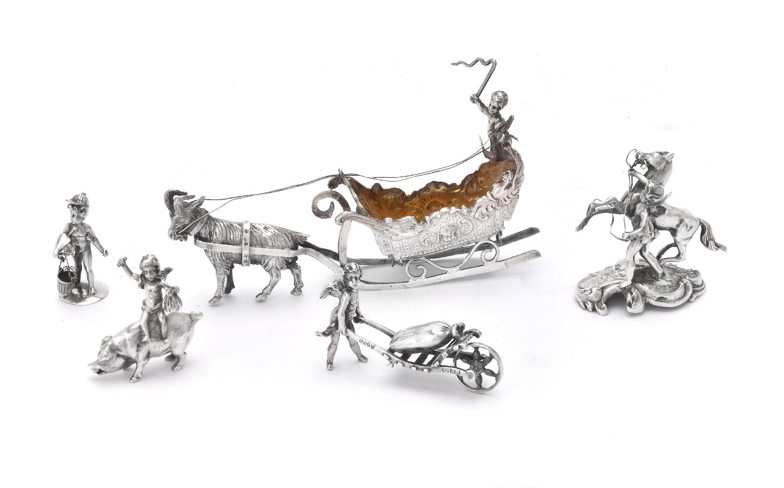 Five Continental silver toys with cherubs: driving a goat drawn sleigh