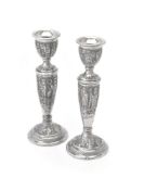 A pair of Persian silver circular candlesticks