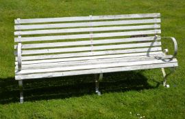 A painted wrought iron and slatted wood garden bench