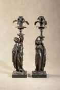 After Jean Jacques Pradier (French, 1790 - 1852), a pair of patinated bronze figural candlesticks in