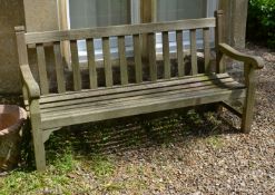 A substantial teak garden seat