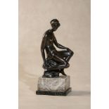 A bronze model of a seated female nude