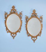 A pair of carved giltwood and gesso oval wall mirrors