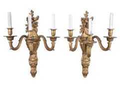 A set of eight gilt bronze three branch wall appliques in Régence taste