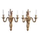 A set of eight gilt bronze three branch wall appliques in Régence taste