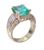 A diamond and emerald dress ring