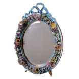 An English porcelain flower encrusted oval looking glass frame with wood easel stand