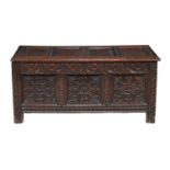 A carved and panelled oak coffer