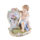 A Meissen menu holder modelled as a kneeling putto with shield