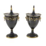 A pair of black and gold painted and lacquered metal chestnut urns and covers in the style of Regenc