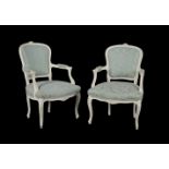 A pair of white painted and turquoise upholstered open armchairs in Louis XVI style