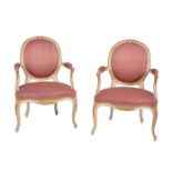 A pair of cream painted and parcel gilt armchairs