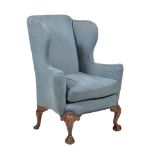 A walnut and upholstered wing back armchair in George II style