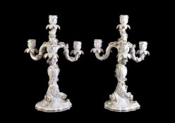 A pair of Meissen white porcelain and gilt four-branch candelabra