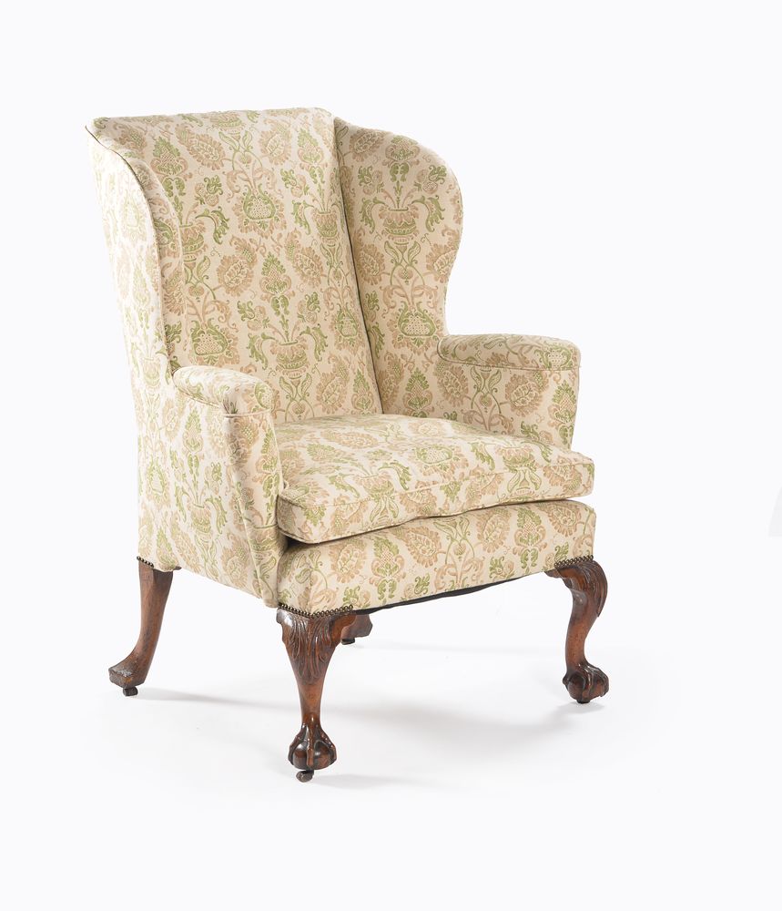 A George II walnut and leather upholstered wing armchair