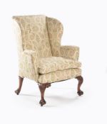A George II walnut and leather upholstered wing armchair