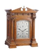 A Victorian carved oak quarter chiming bracket clock