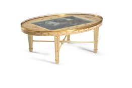 An ‘ivory’ painted and parcel-gilt oval low table, the brass galleried top with a central glazed