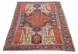 A Serapi carpet, the navy cream and madder field decorated with stylised foliage throughout and