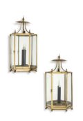 A pair of gilt metal and glazed wall lanterns, 20th century, each of polygonal section, beneath a
