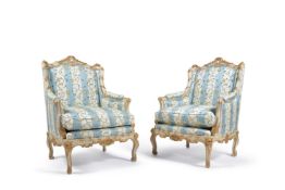 A pair of painted and gilded beechwood fauteuils, the carved frame decorated with reeding and