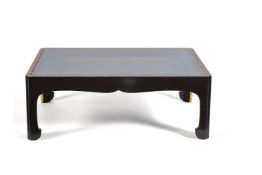 A black lacquered and parcel gilt low centre table, 20th century, the glazed top enclosing a central