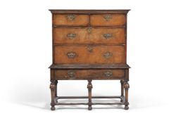 A walnut and feather banded chest on stand, early 18th century and later, the chest with arrangement