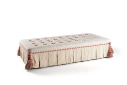 A rectangular cream button upholstered centre footstool, late 20th century, with tassels to each