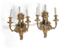 A pair of gilt and patinated bronze three light wall appliques in Regence taste, 20th century, the