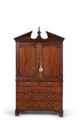 A George III mahogany linen press, late 18th century, the broken arched pediment centred by a carved