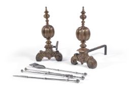 A pair of brass and wrought iron andirons in Baroque taste, the knopped finials above gadrooned ball