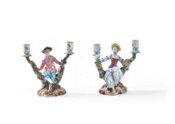 A pair of Meissen two-branch flower-encrusted figural candlesticks depicting gallant and