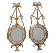 A pair of George III giltwood and composition wall mirrors, early 19th century, the bow and swag