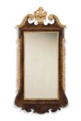 A George II walnut and parcel gilt wall mirror, mid-18th century, the broken swan neck pediment