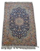 A Nain rug, the dark blue centre ground with central ivory medallion, pink and ivory flowers,