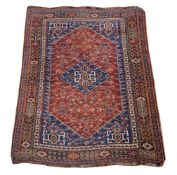 An Afshar rug, the blue field with stylised floral motifs around a blood-red hexagonal panel with