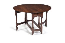 A George II solid yew wood gateleg table, circa 1735, with single frieze drawer and on turned