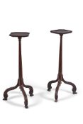 A pair of mahogany torcheres in George III style, 19th century, each with shaped square top above