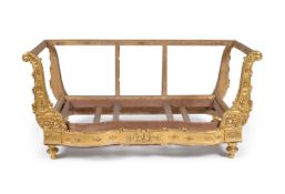 A French carved giltwood and gesso daybed frame, 19th century, the scrolling arm facings with