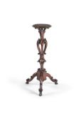 A carved walnut candlestand, mid 19th century, the polygonal top with brass moulded edge on