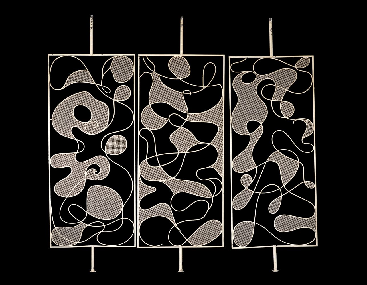 A three-section painted metal screen or room divider