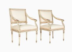 A pair of white painted and parcel gilt open armchairs