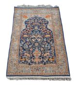 A Qum carpet with indigo field with a madder medallion and lion standards