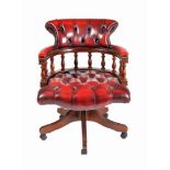A modern reproduction leatherette upholstered revolving desk chair